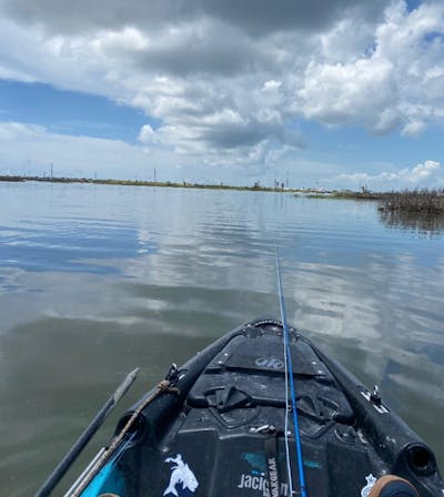 View of a boat and a fly rod in a body of water.