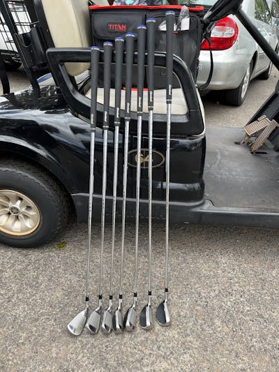 The Cleveland Golf Launcher HB Turbo Iron Set resting on a golf cart. 