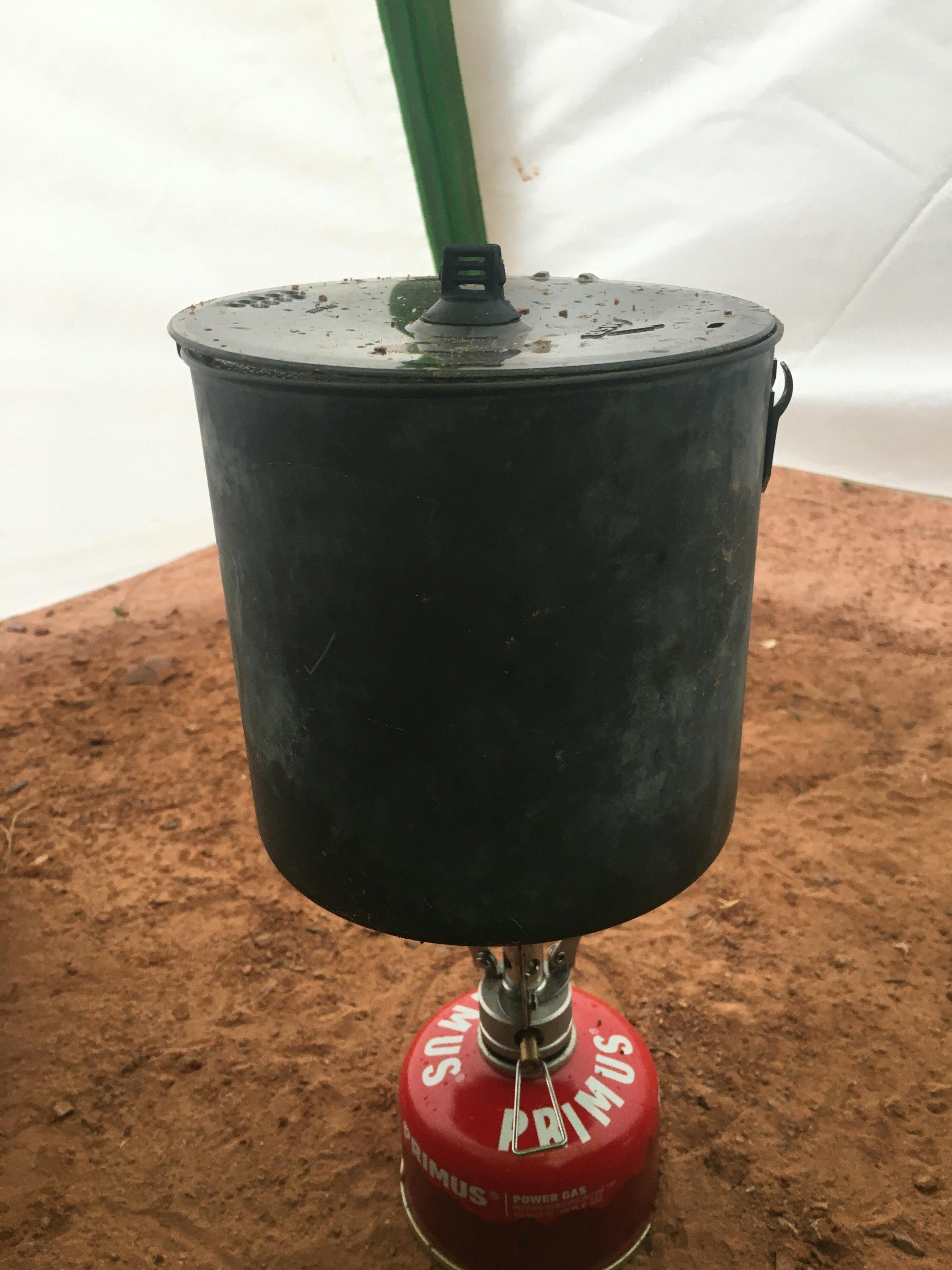A pot on a camping stove inside a tent. 
