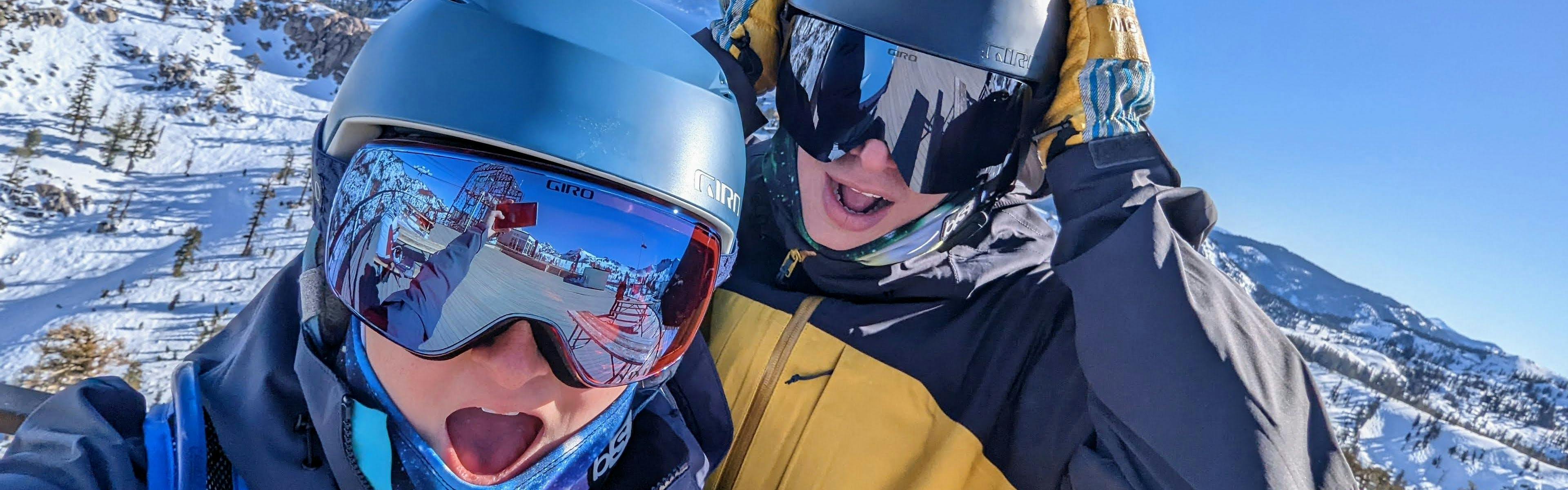A selfie of two skiers on a ski mountain. 