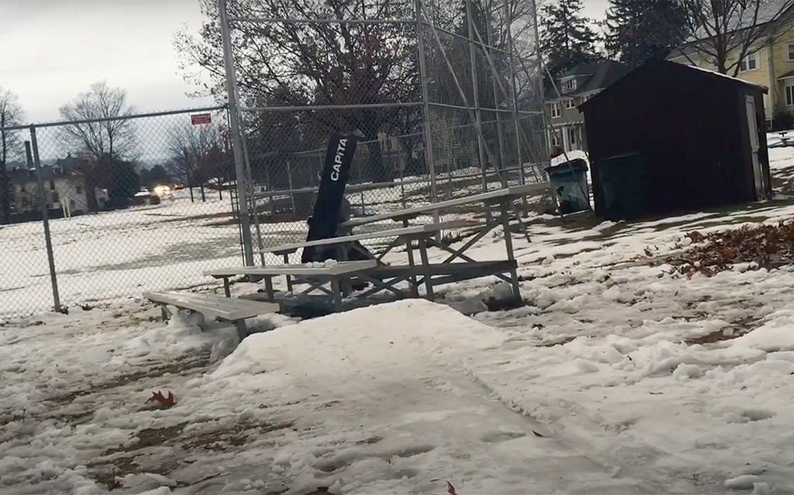 A snowboarder falls off a table.