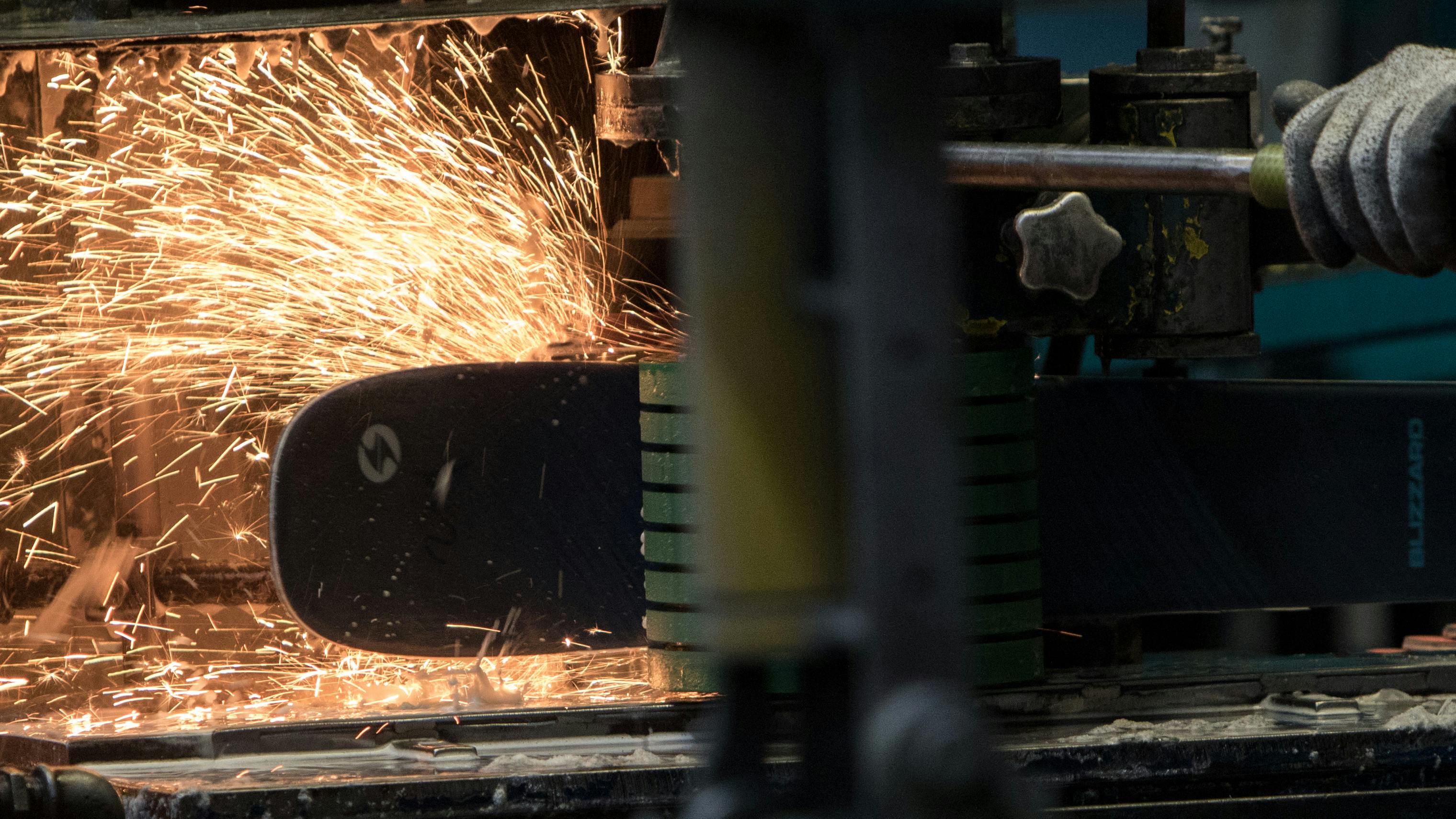 Sparks flying from a ski getting worked on in a factory