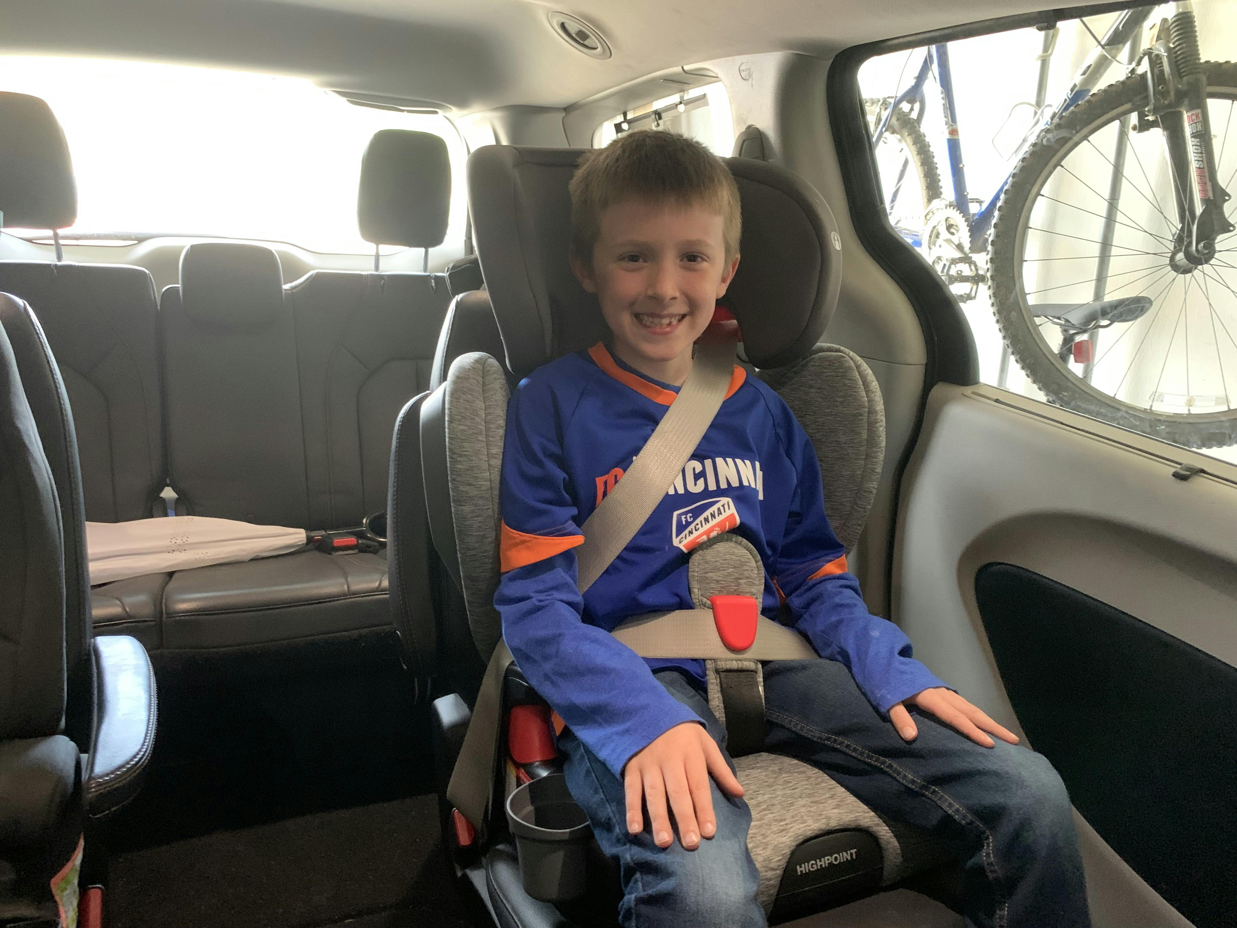 A smiling child in the Britax Highpoint 2-Stage Booster Car Seat.