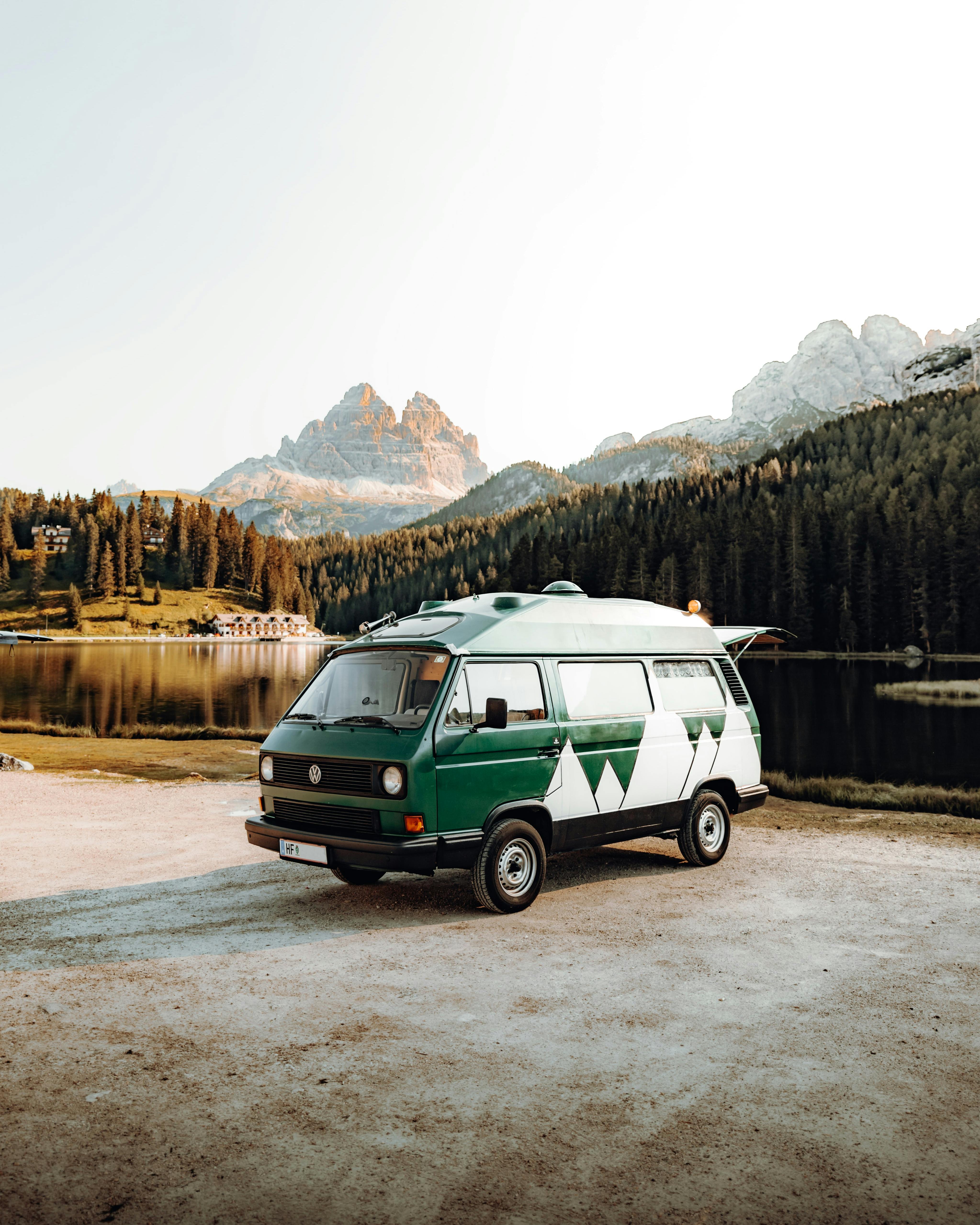 A camper van with forest and  mountains in the background
