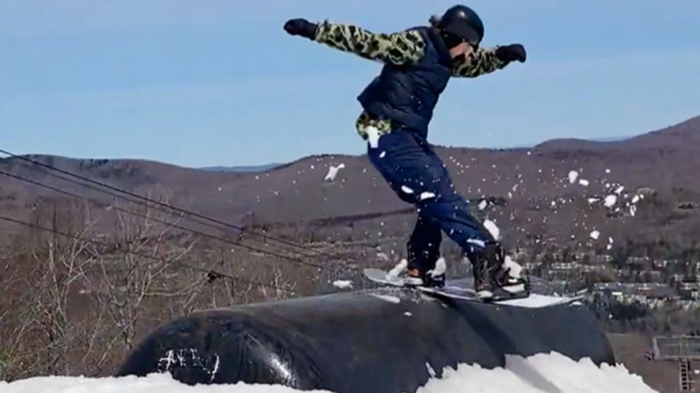 A snowboarder hitting a rail on the Rome Party Mod Snowboard.