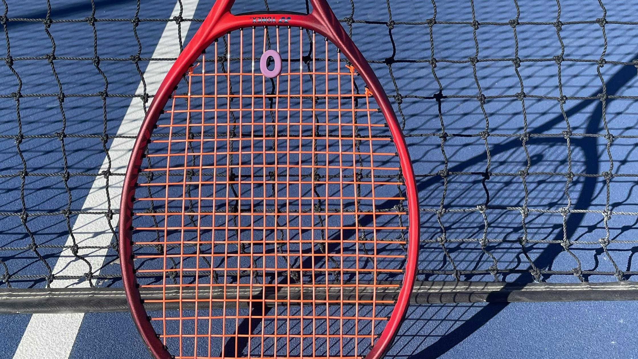 The Yonex VCore 98+ Racquet · Unstrung on a tennis court. 