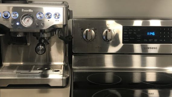 The Breville Barista Express on a counter in a kitchen.