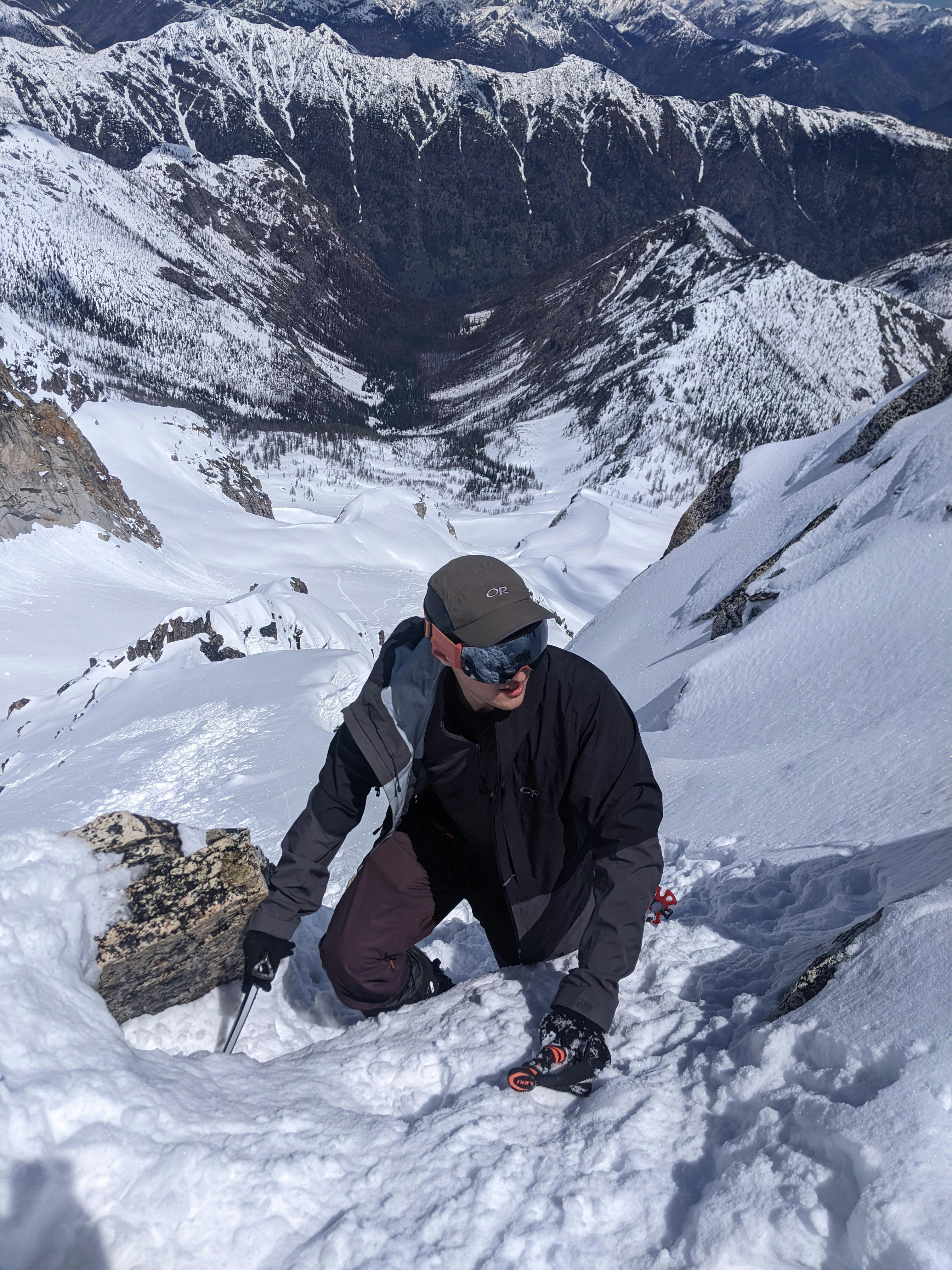 A hiker walking up a snowy mountain in the Smith I/O MAG Goggles.