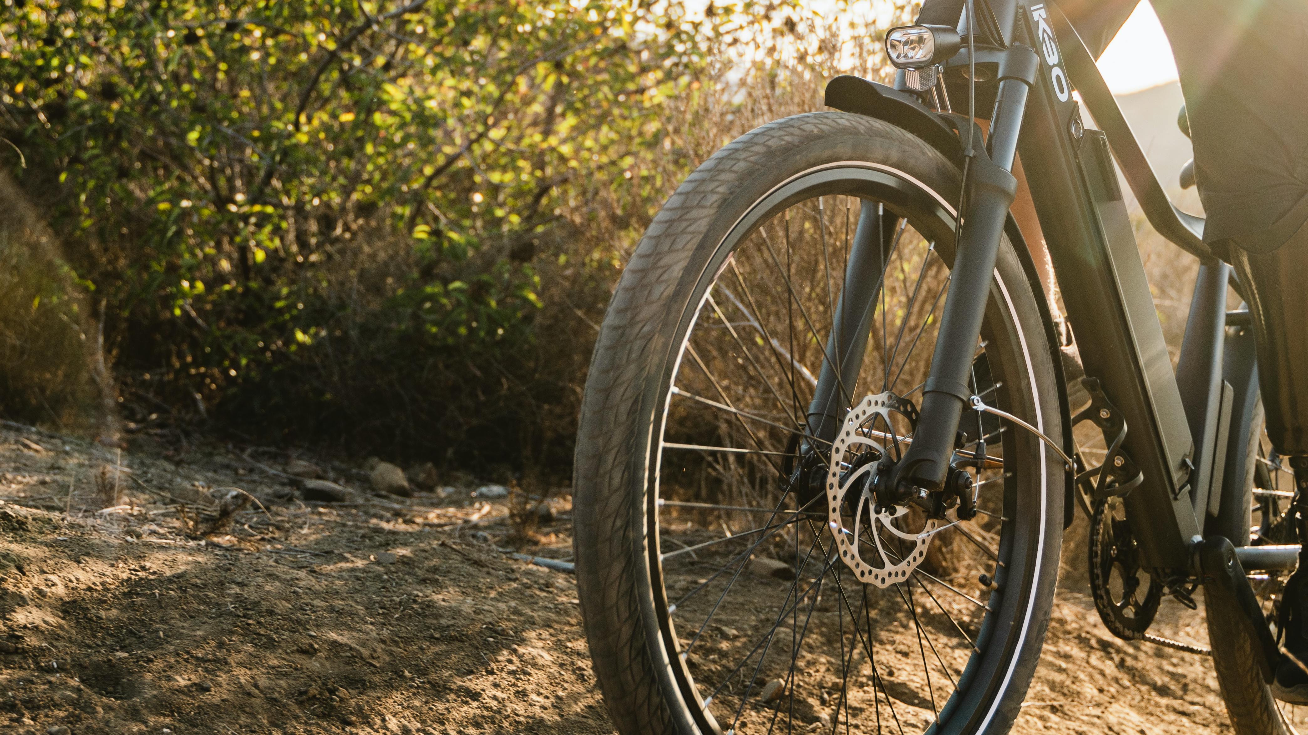 Close up of a mountain bike as a biker pedals it up a dirt trail. 