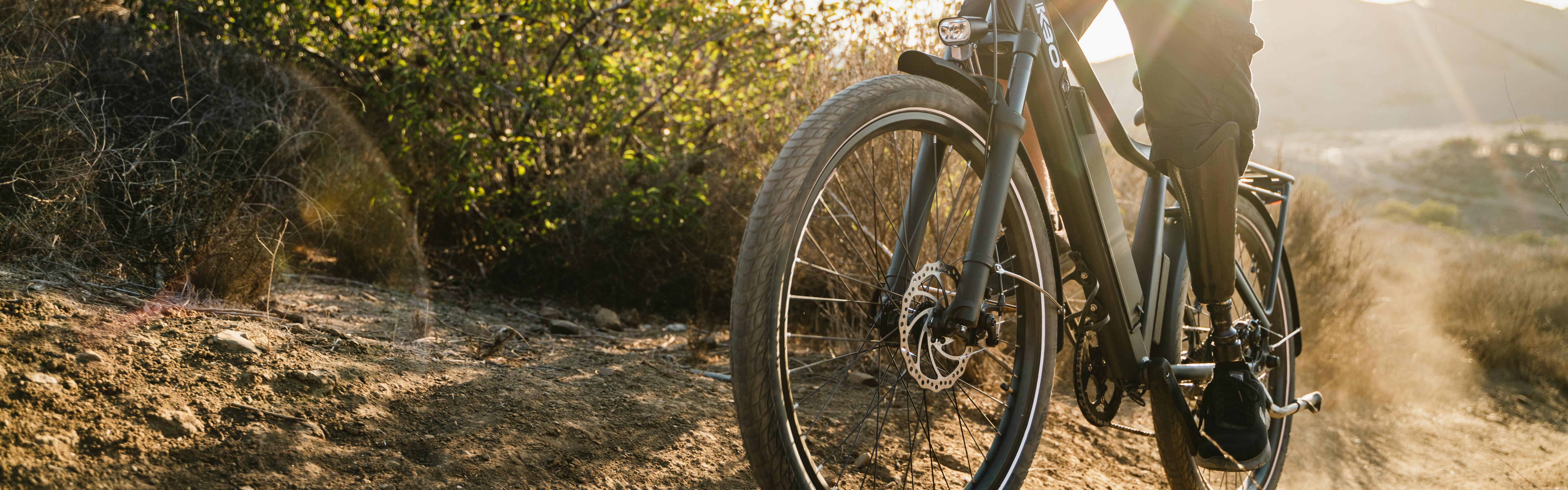Close up of a mountain bike as a biker pedals it up a dirt trail. 