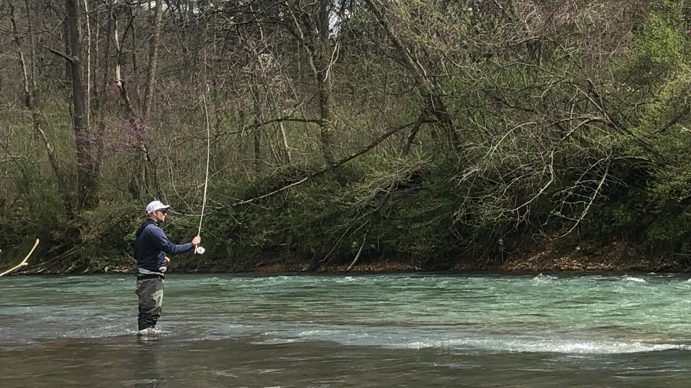 A man fishing with the Simms Men's G3 Guide Stockingfoot Waders on. He is standing in a river. 