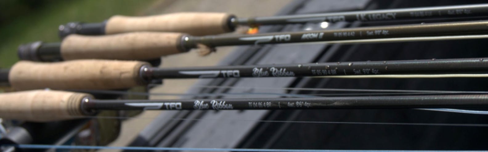 Four fly rods lie in a row. 