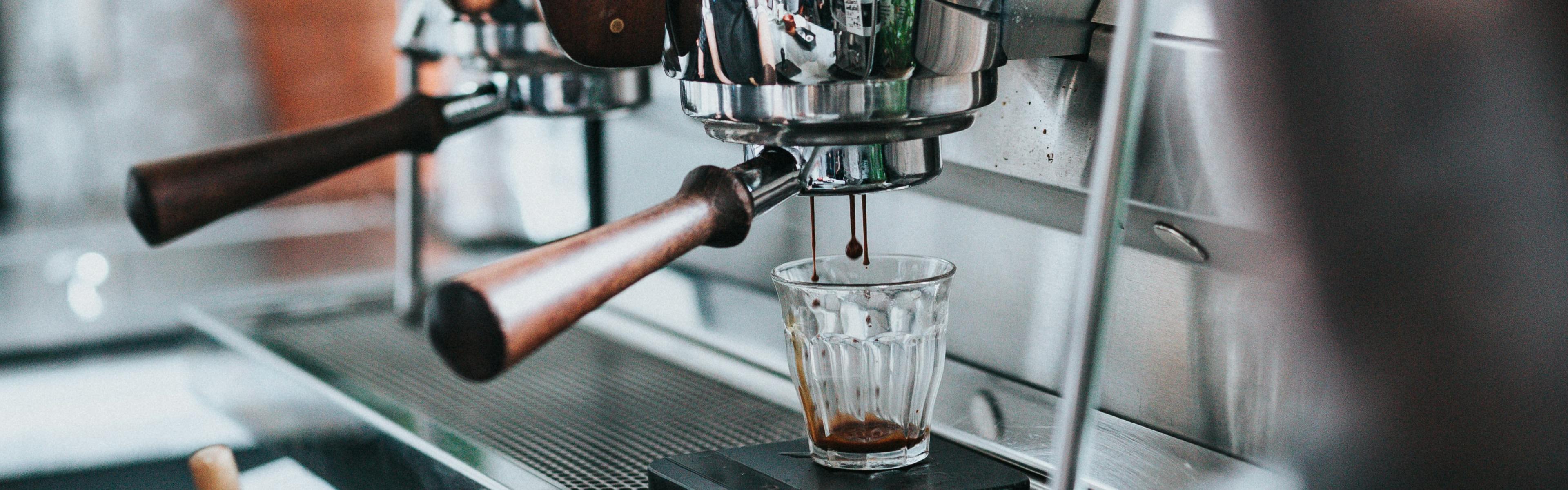 An espresso machine makes a shot into a glass cup.