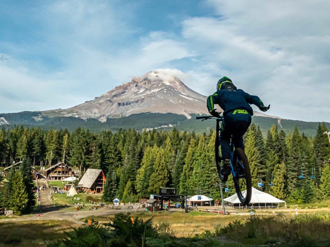 A man jumps on his bike while riding towards Mt. Hood.