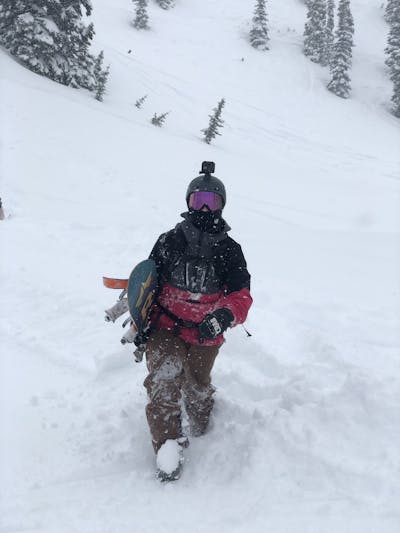 A snowboarder holding his snowboard. 