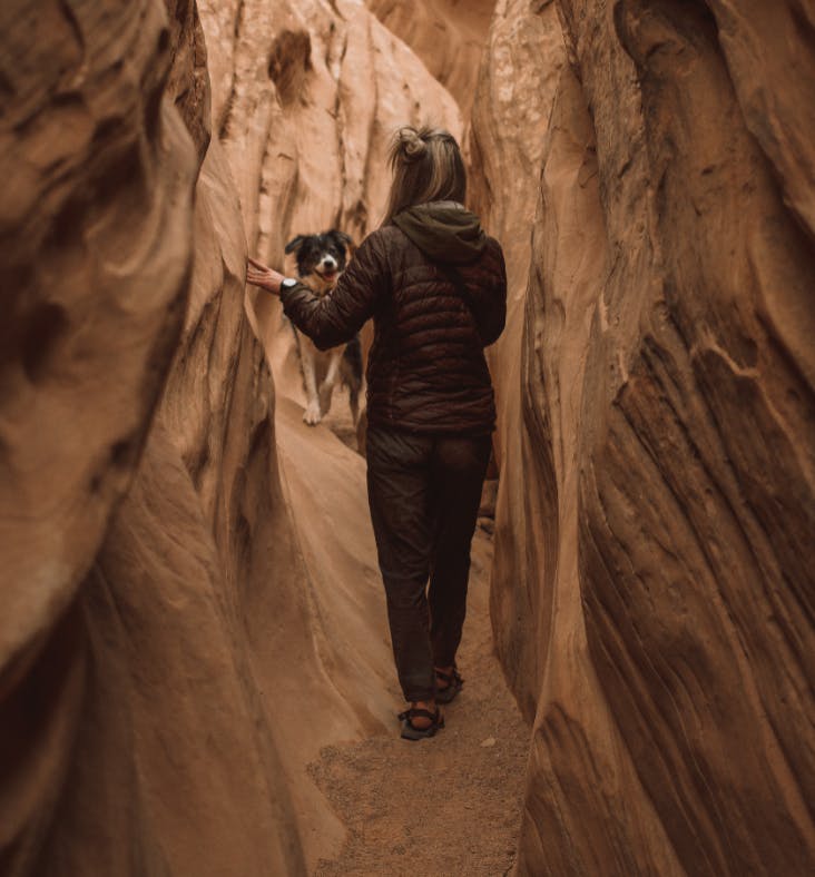 A dog and a girl in a slot canyon. 