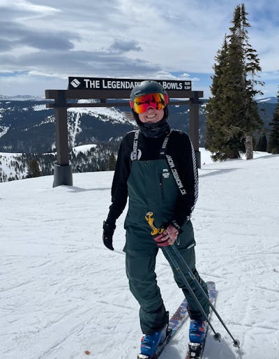 A woman at the top of a ski run wearing the Smith I/O MAG XL Goggles.