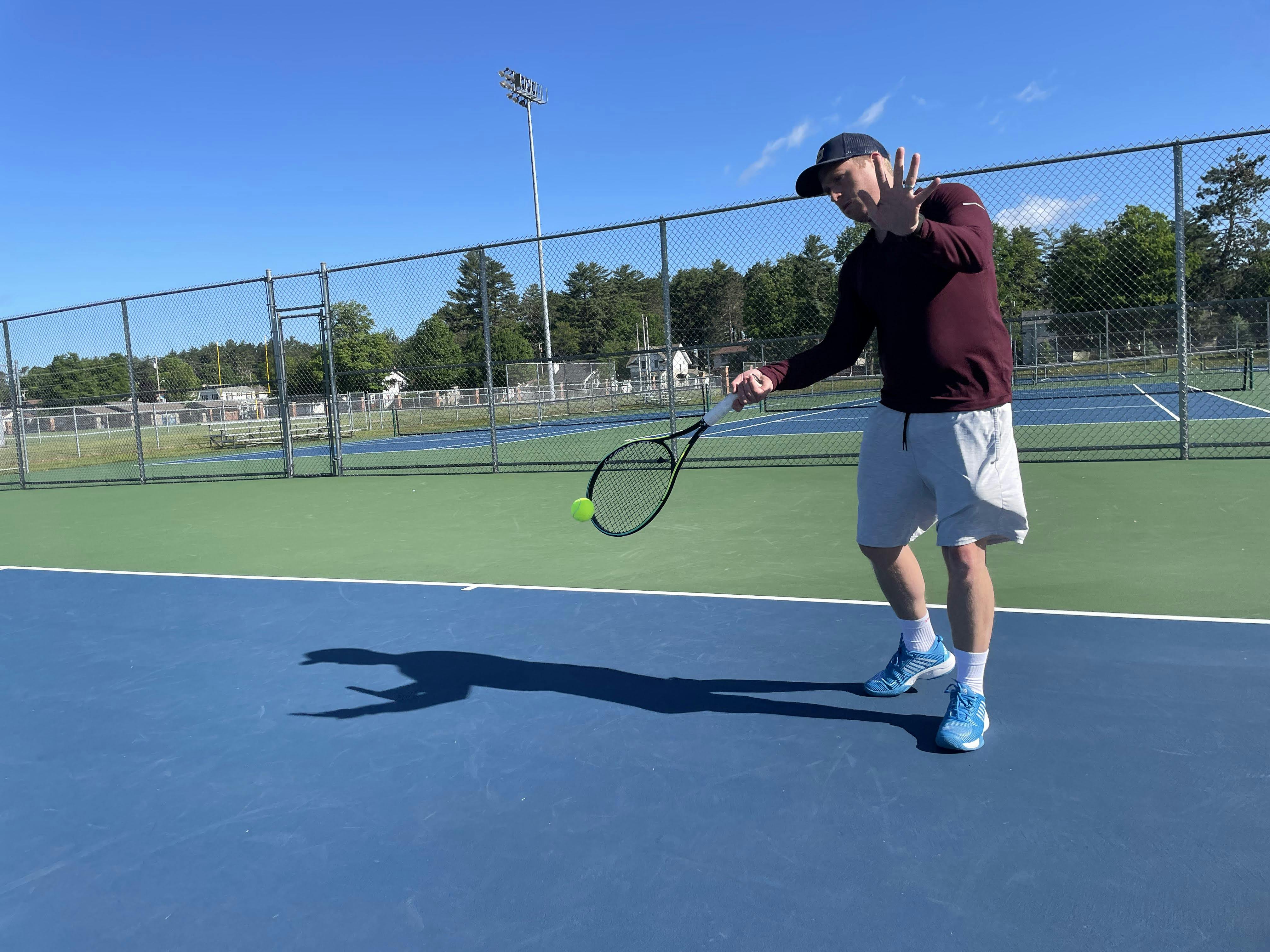 An expert playing tennis with Head Gravity MP Racquet.