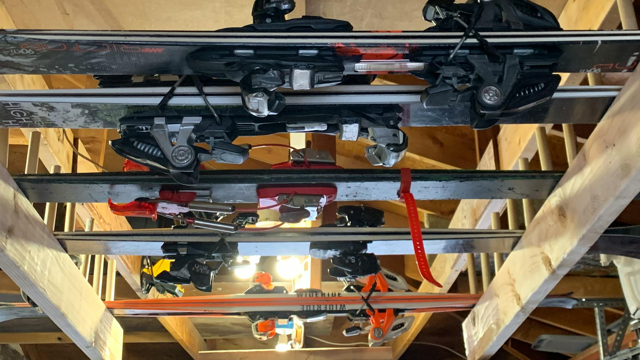 Multiple pairs of skis on a ceiling garage rack