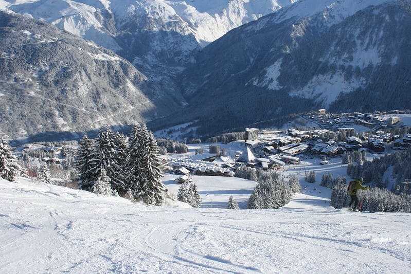 A snowy ski resort with a town below it. 