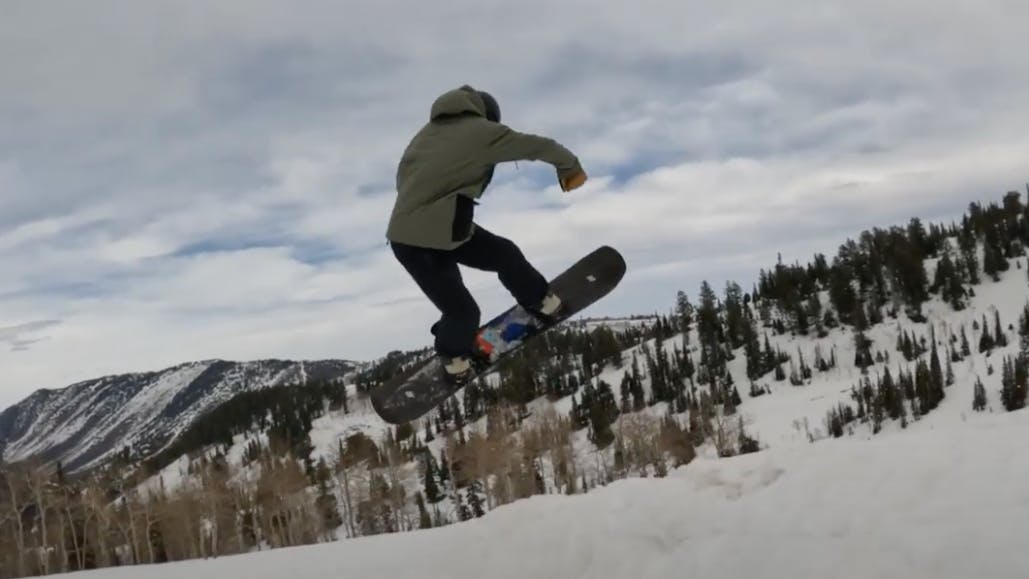 Curated Snowboard Expert Spencer Storck jumping with the 2023 K2 Afterblack snowboard