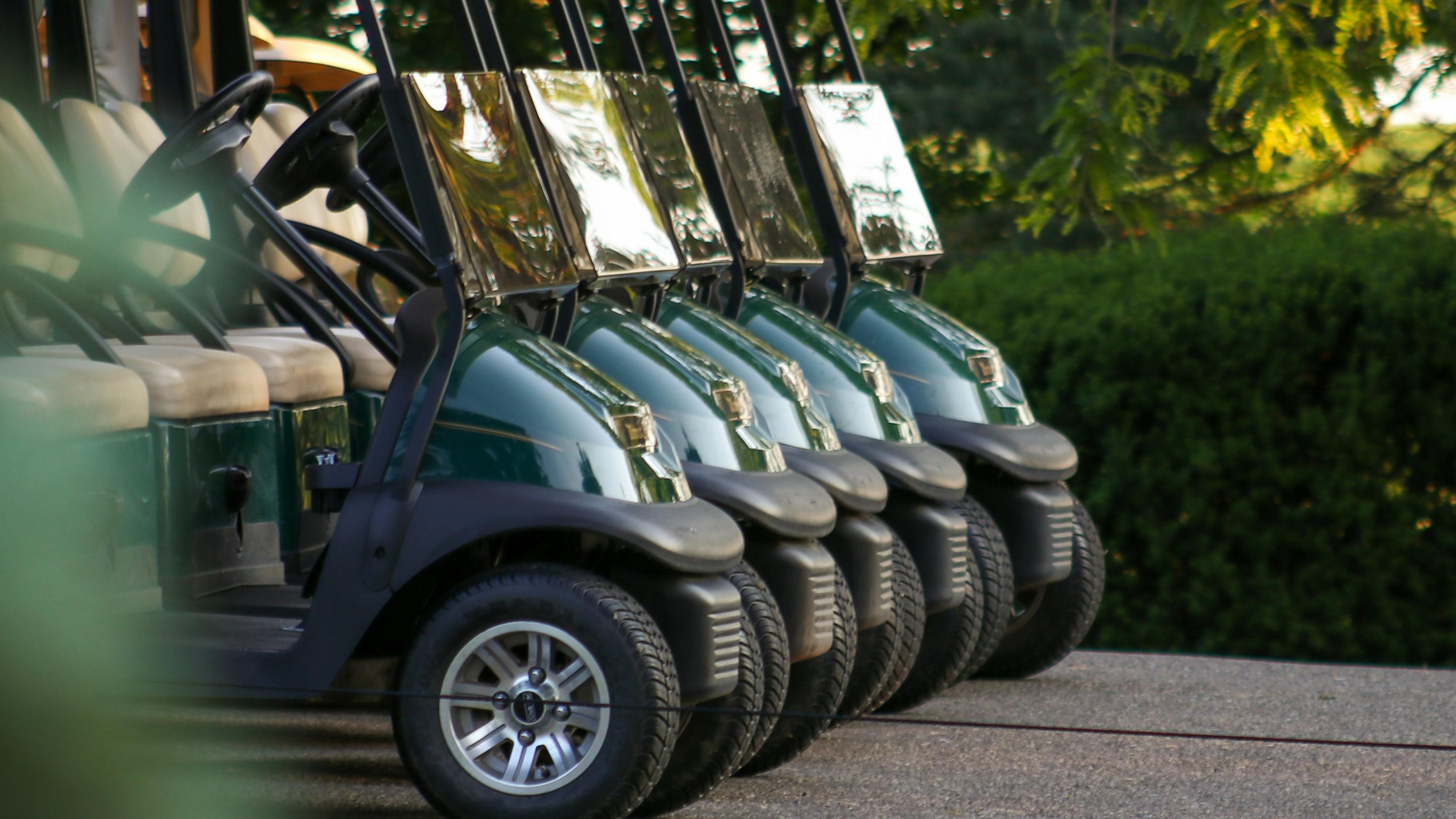 Golf carts all parked in a line.