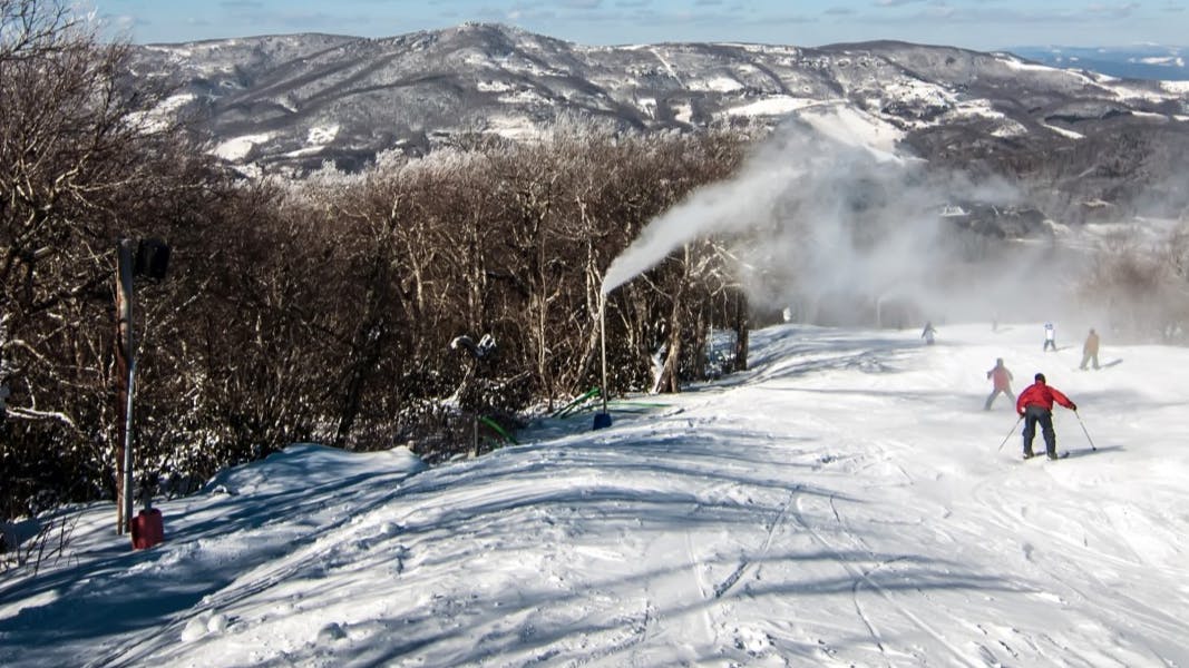 A skier going down a ski trail at a ski resort. 