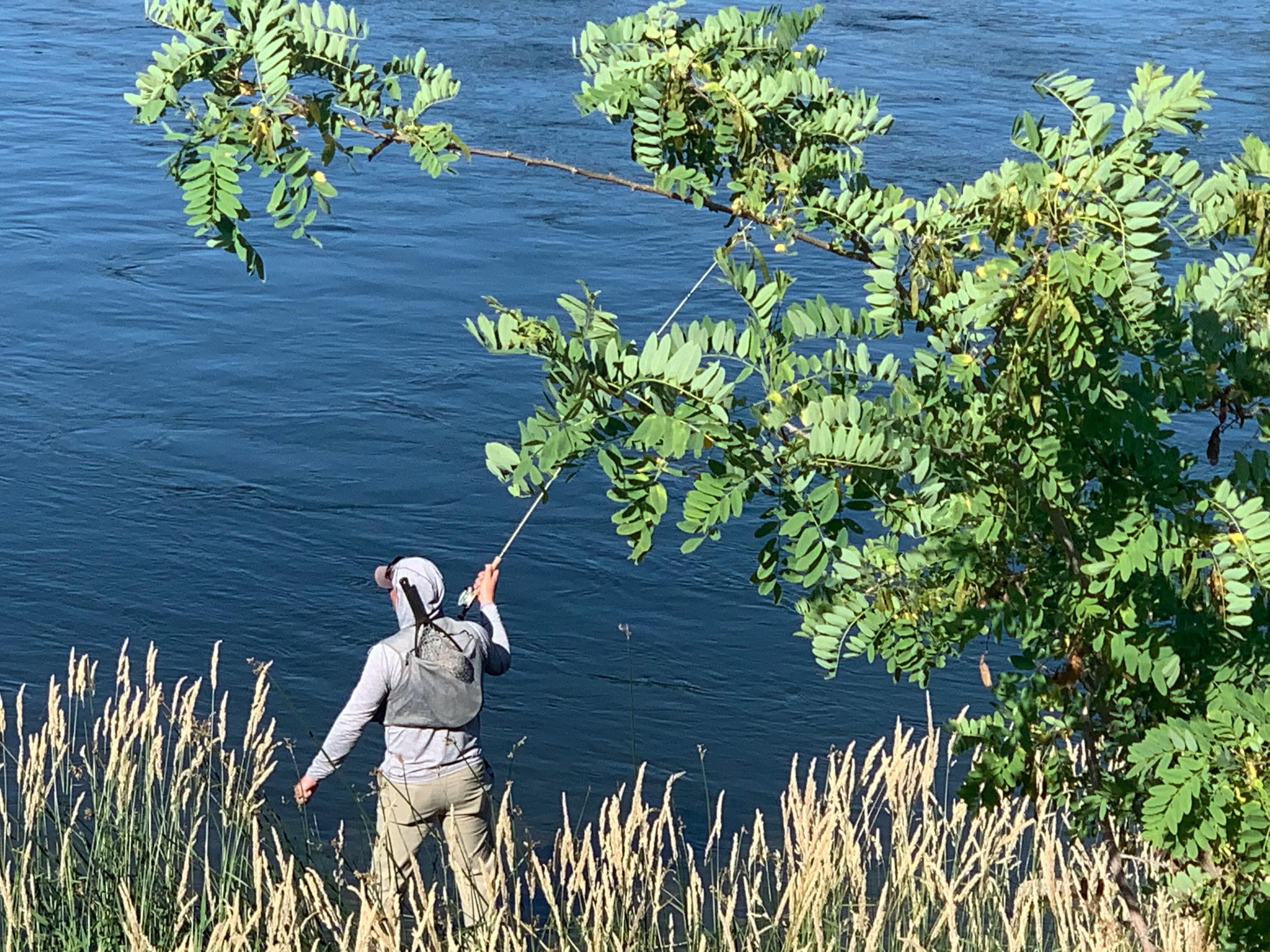 A man fishing in the North Face Wander Hoodie. 