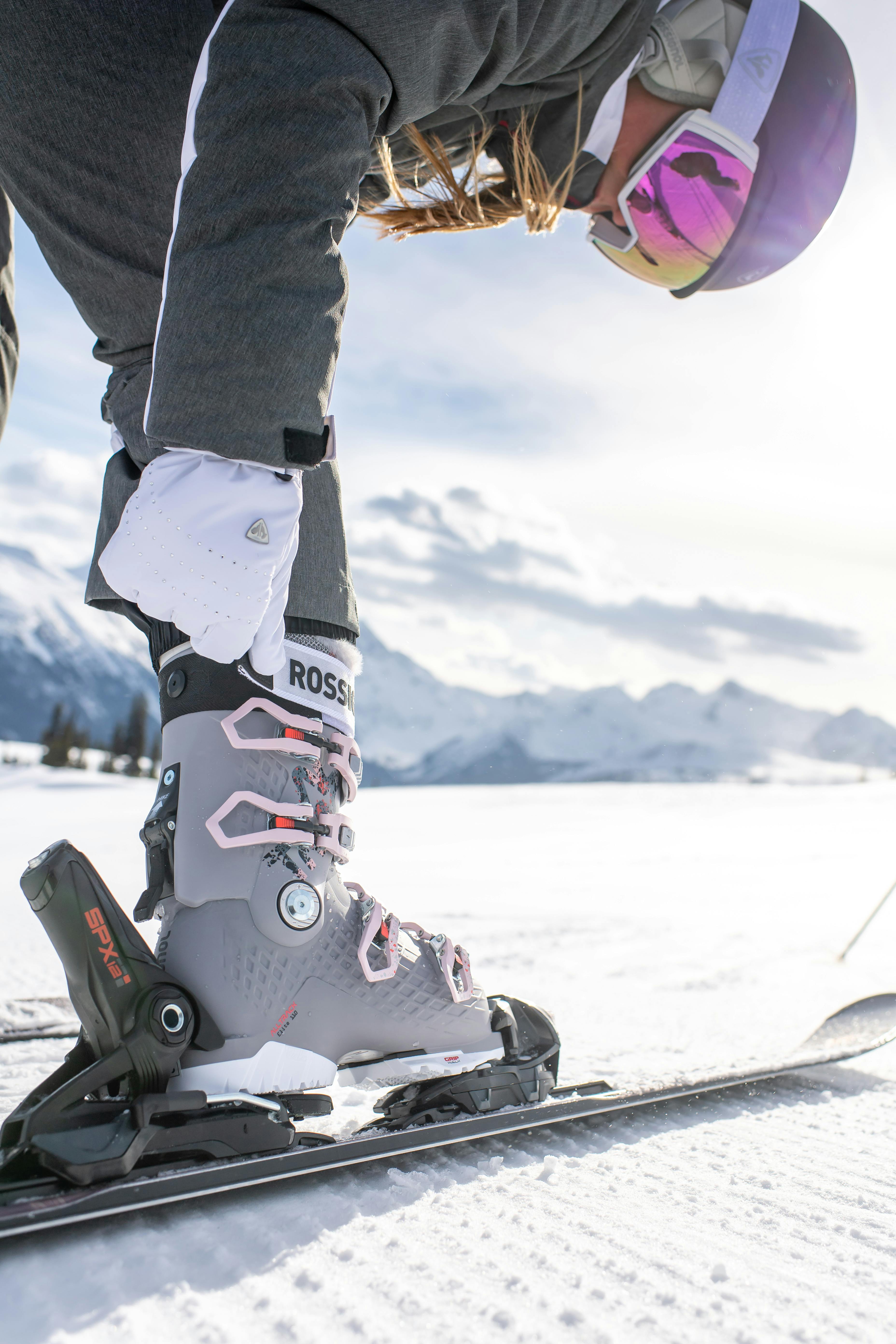 A woman tightens her Rossignol ski boot. 