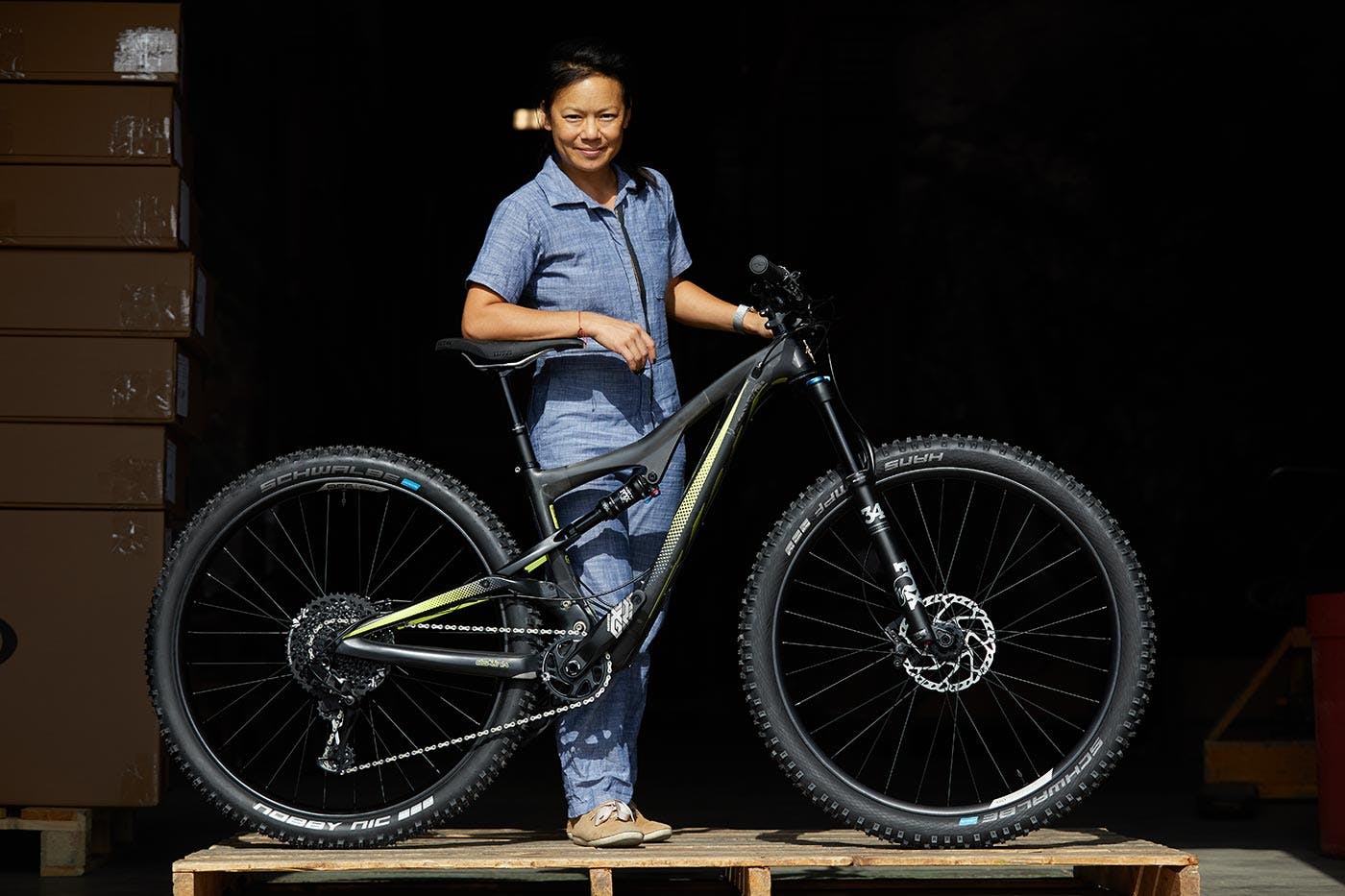 Ibis Cycles Co-owner and Lead Designer Roxy Lo standing with a mountain bike on a platform.