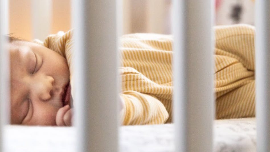 A baby sleeping in a crib. 