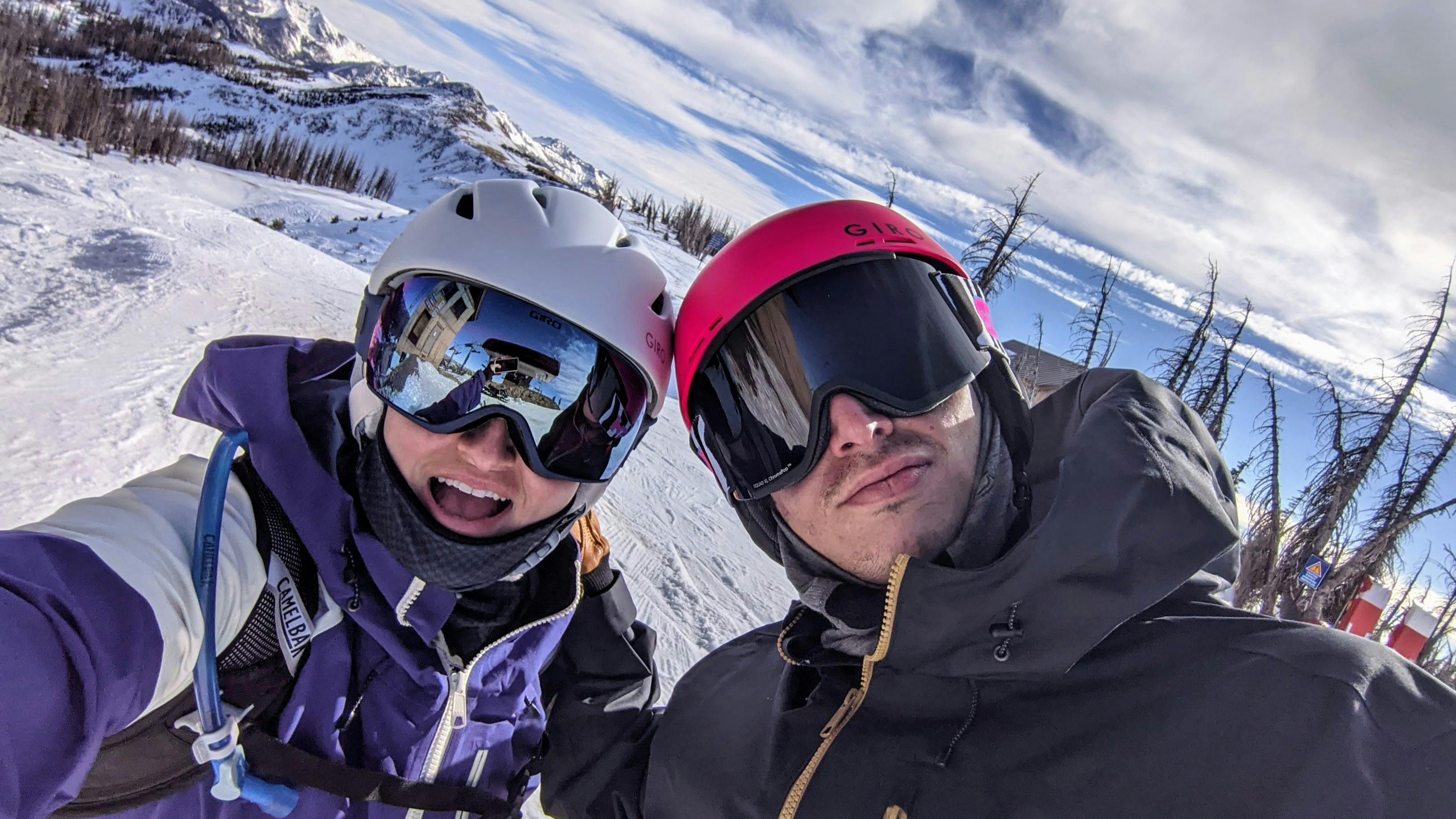 A selfie of two people in ski gear at a ski resort. 