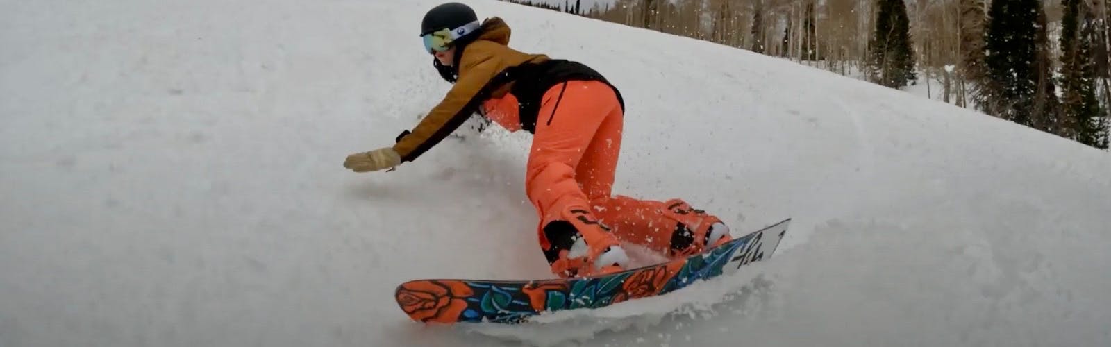 Snowboard Expert Sydney Johnson carving with the Lib Tech Dynamiss snowboard on a groomed run