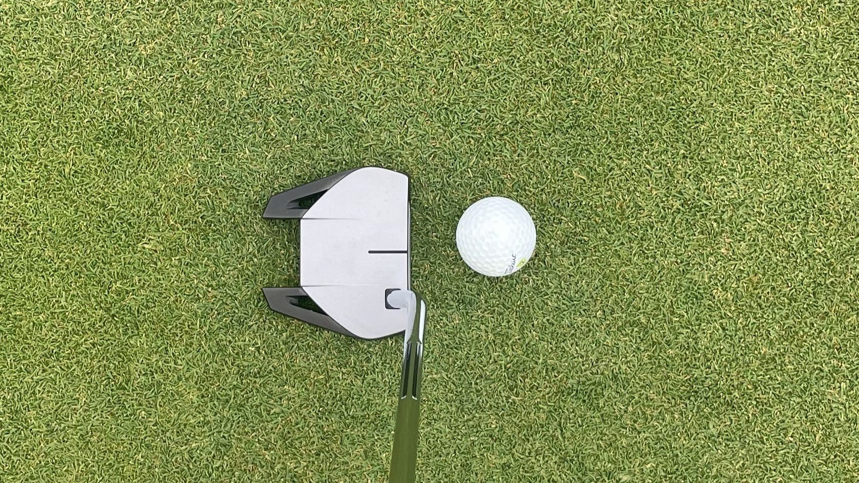 The TaylorMade Spider GT Silver Single Bend Putter in front of a golf ball.