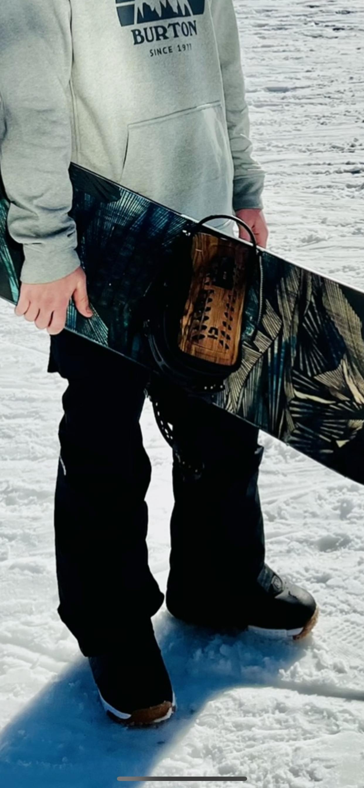 A man holding a snowboard and wearing the DC Control Snowboard Boots. 