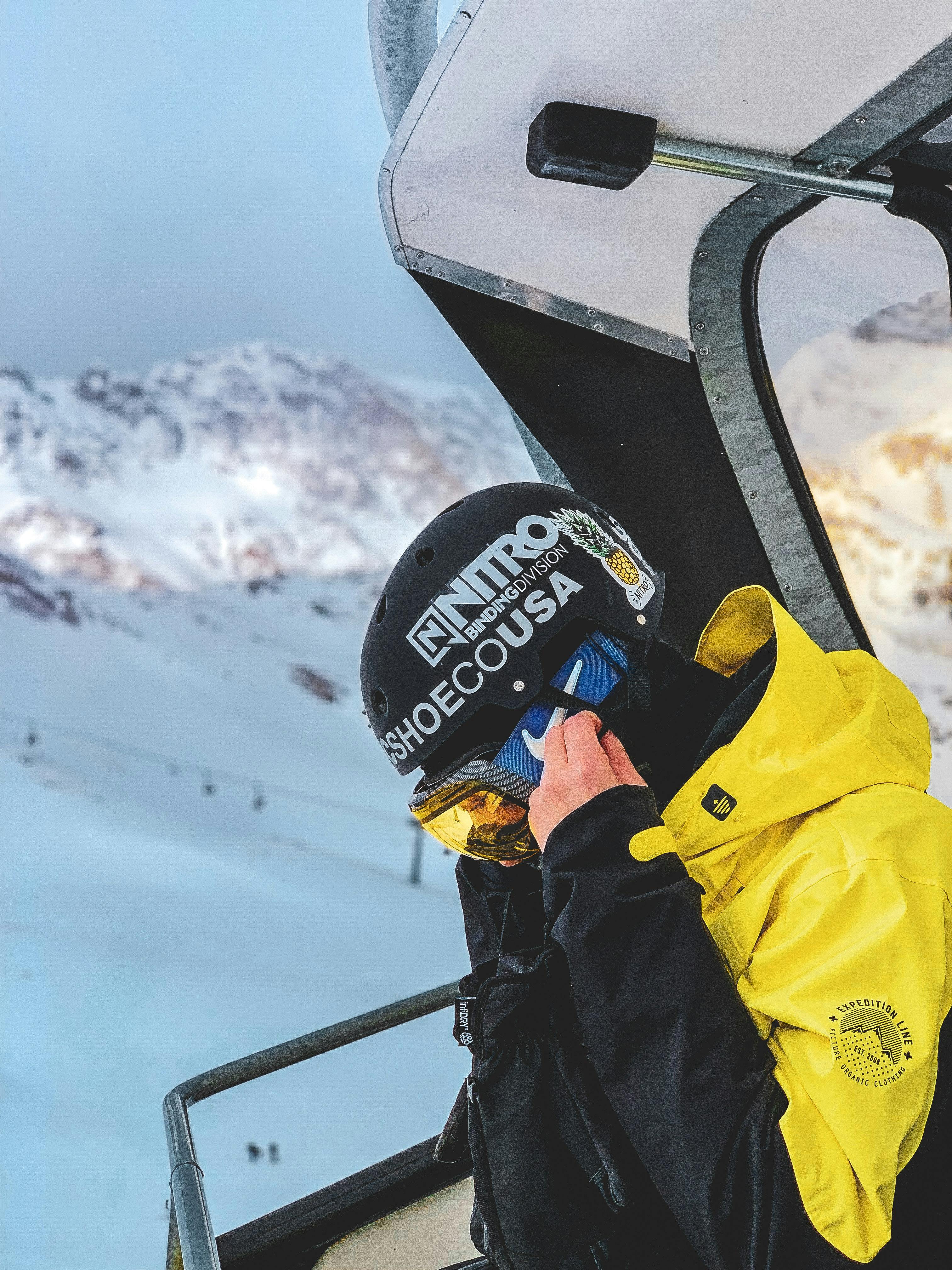 A snowboarder in a yellow jacket on a chairlift