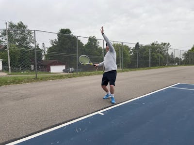 A tennis player serving with Head Graphene 360+ Extreme Tour.