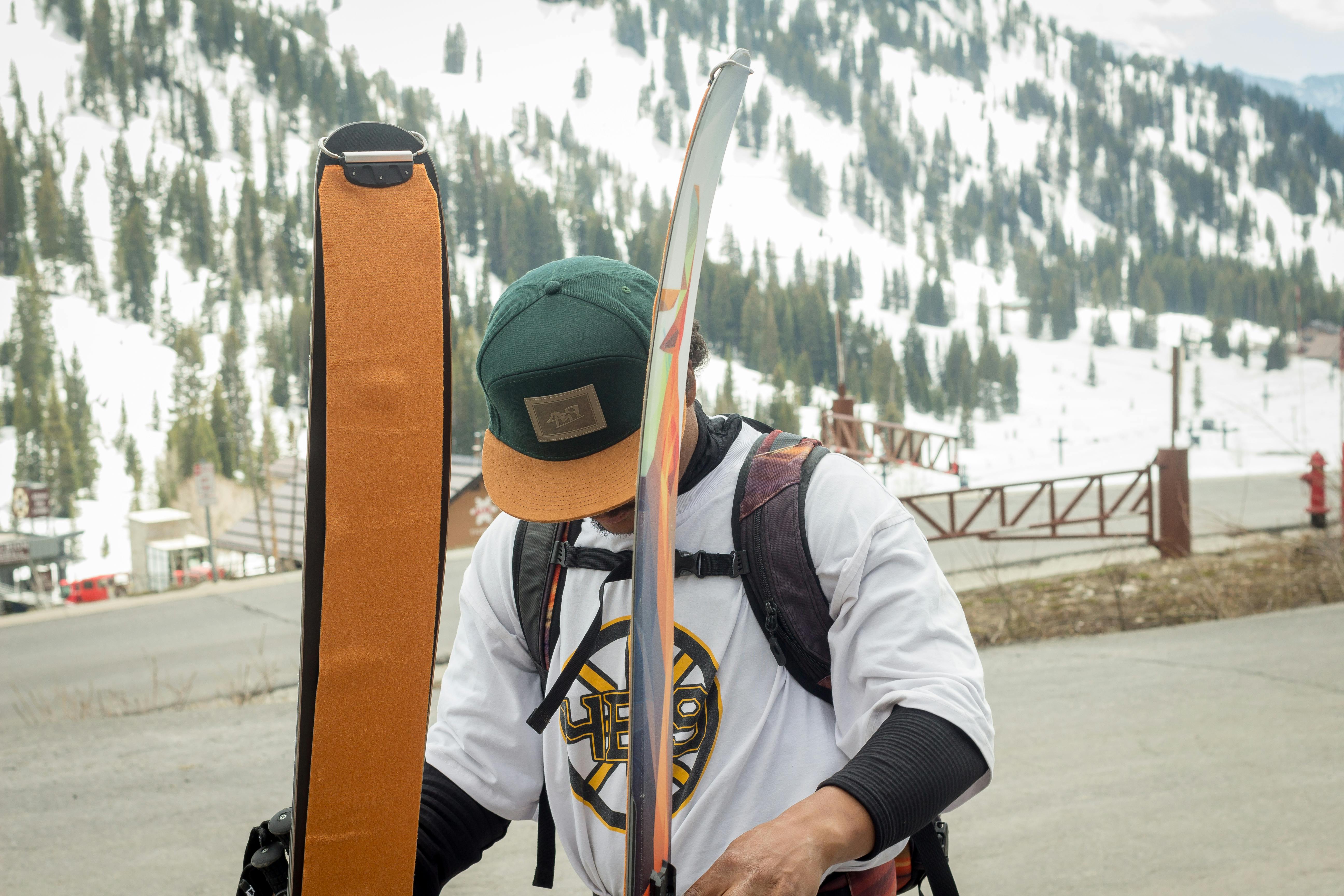 A skier with climbing skins on his skis holds his skis.