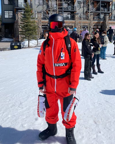 A man standing at the base of a ski resort while wearing the 686 GLCR Men's Hydra Thermagraph Insulated Jacket.