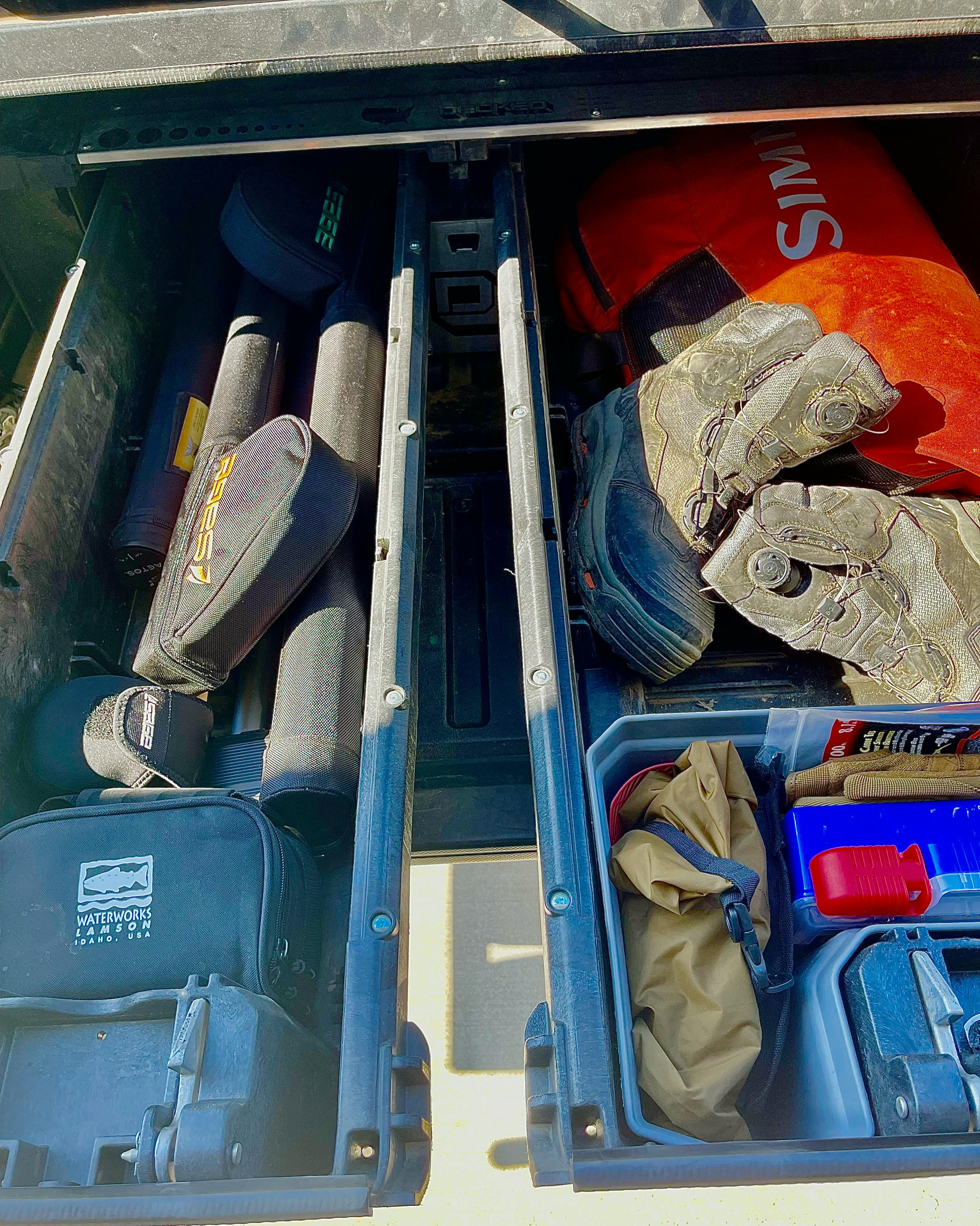 Some various fishing gear lies in a drawer.