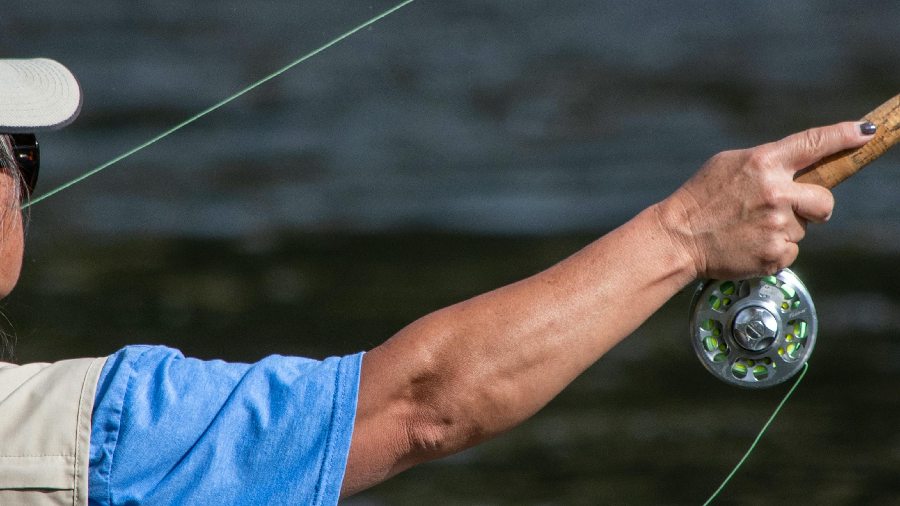 A man casting a fly fishing rod. 