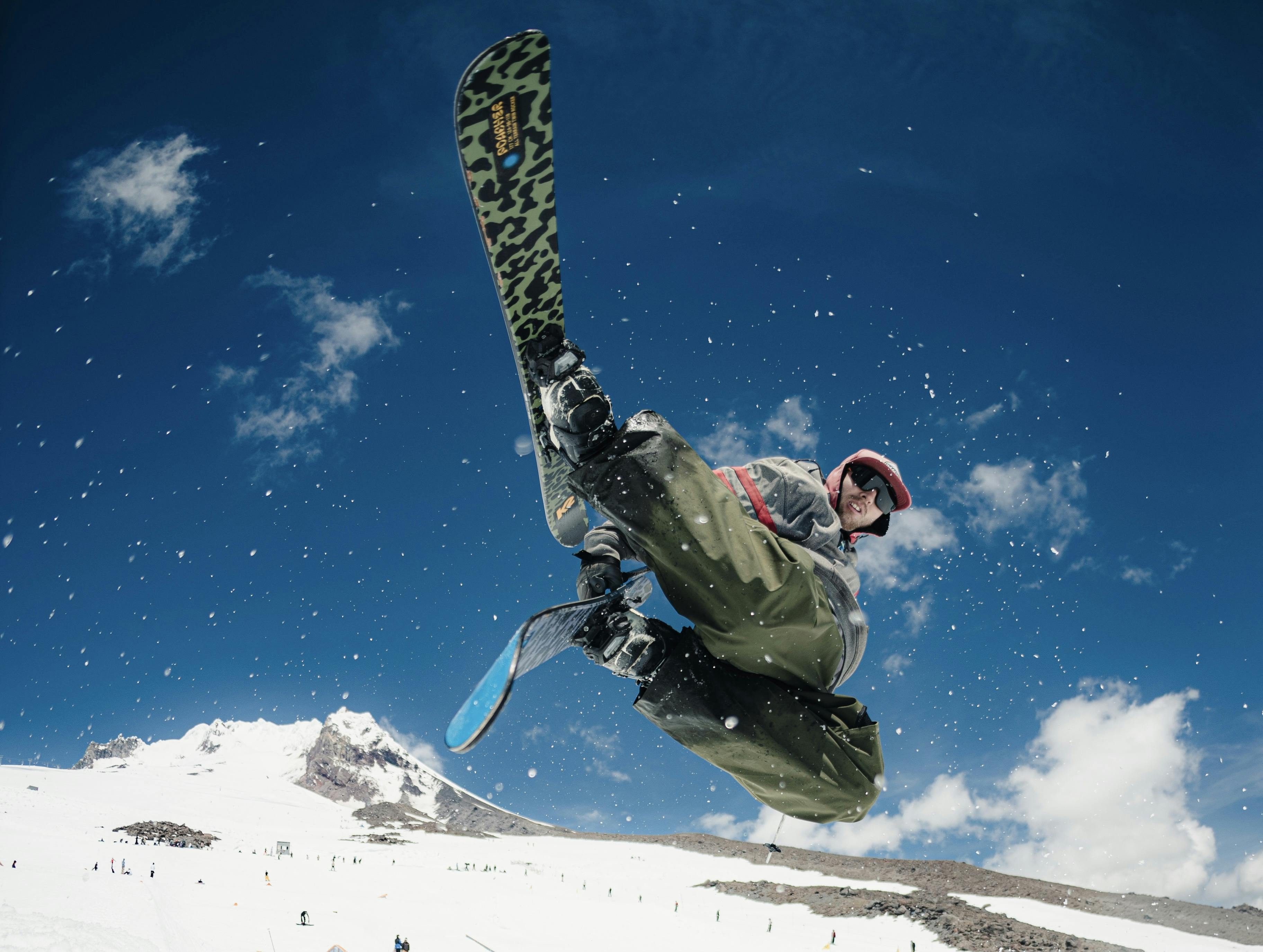 A skier grabs his skis as he does a jump in the air. 
