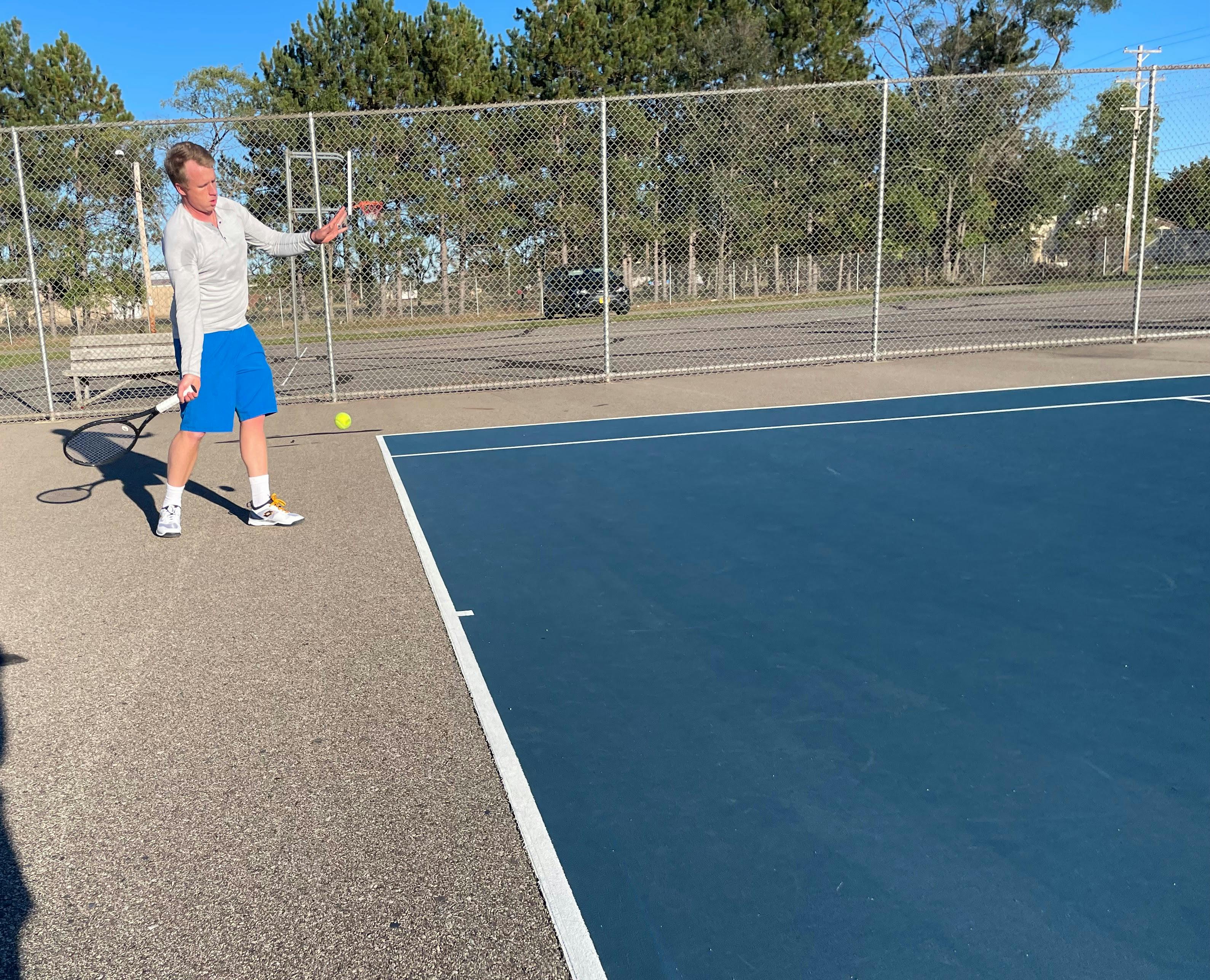 A man taking a swing with the Wilson Pro Staff RF 97 V13.0 Racquet.