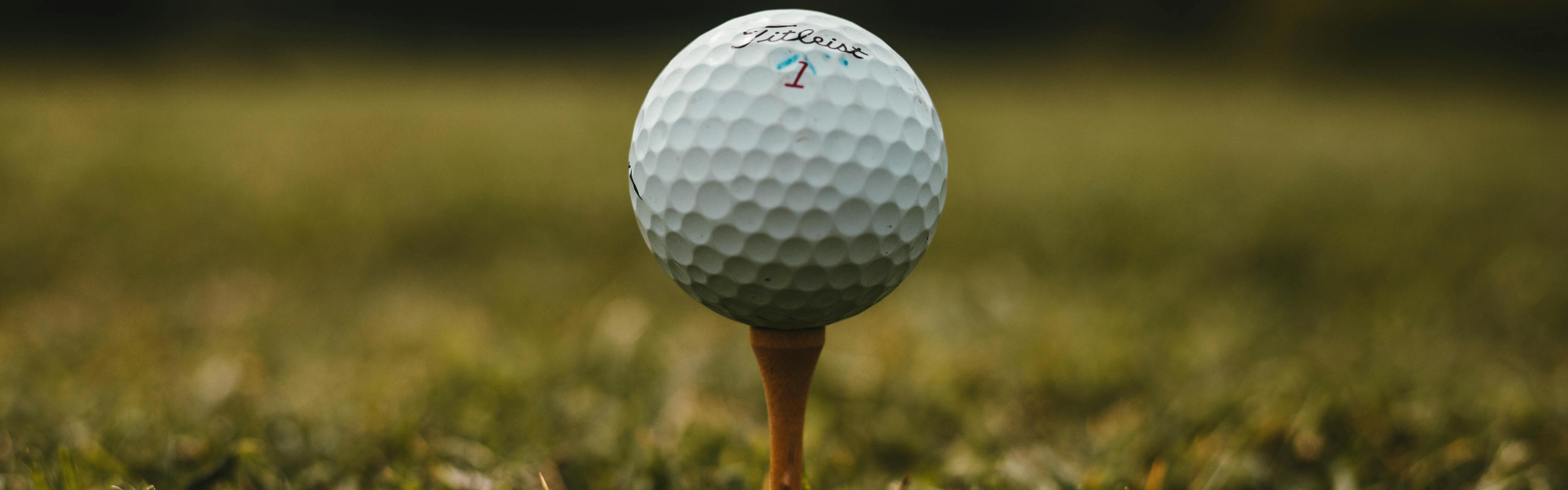 A golf ball sitting on a tee.