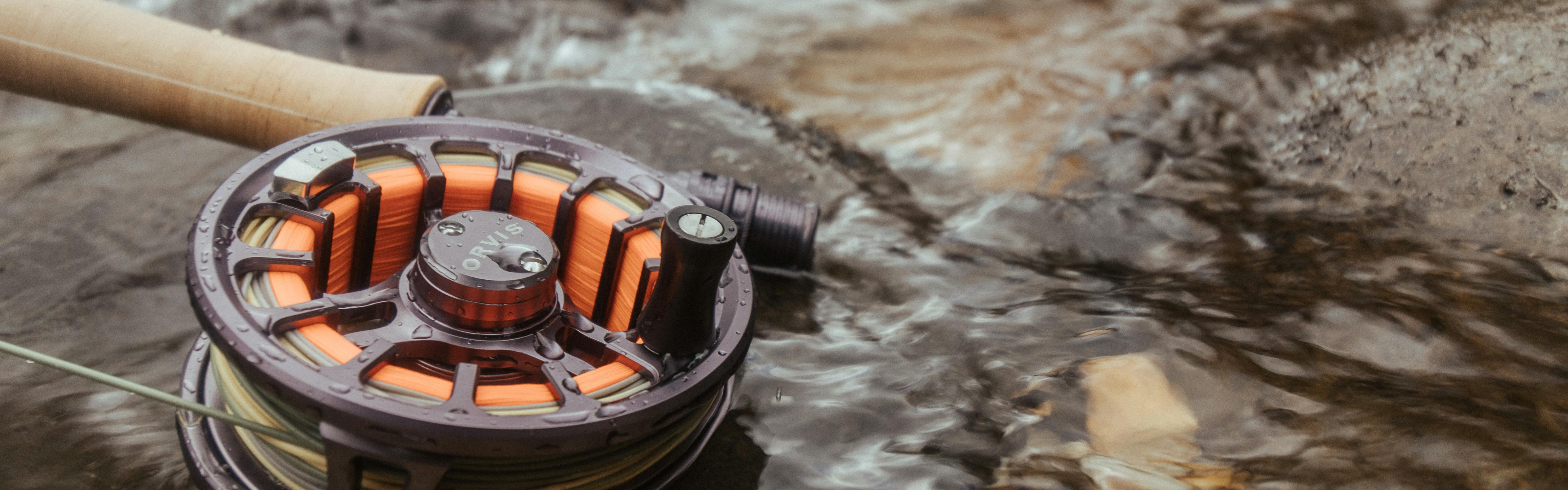 A fishing reel and rod sitting in water. 