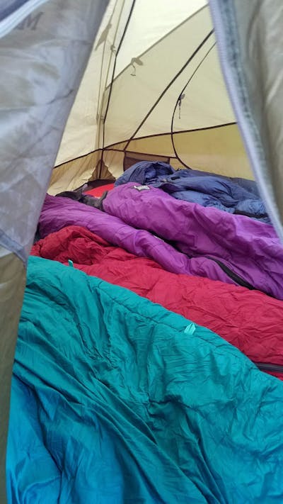 Inside view of a tent with 4 sleeping bags inside.