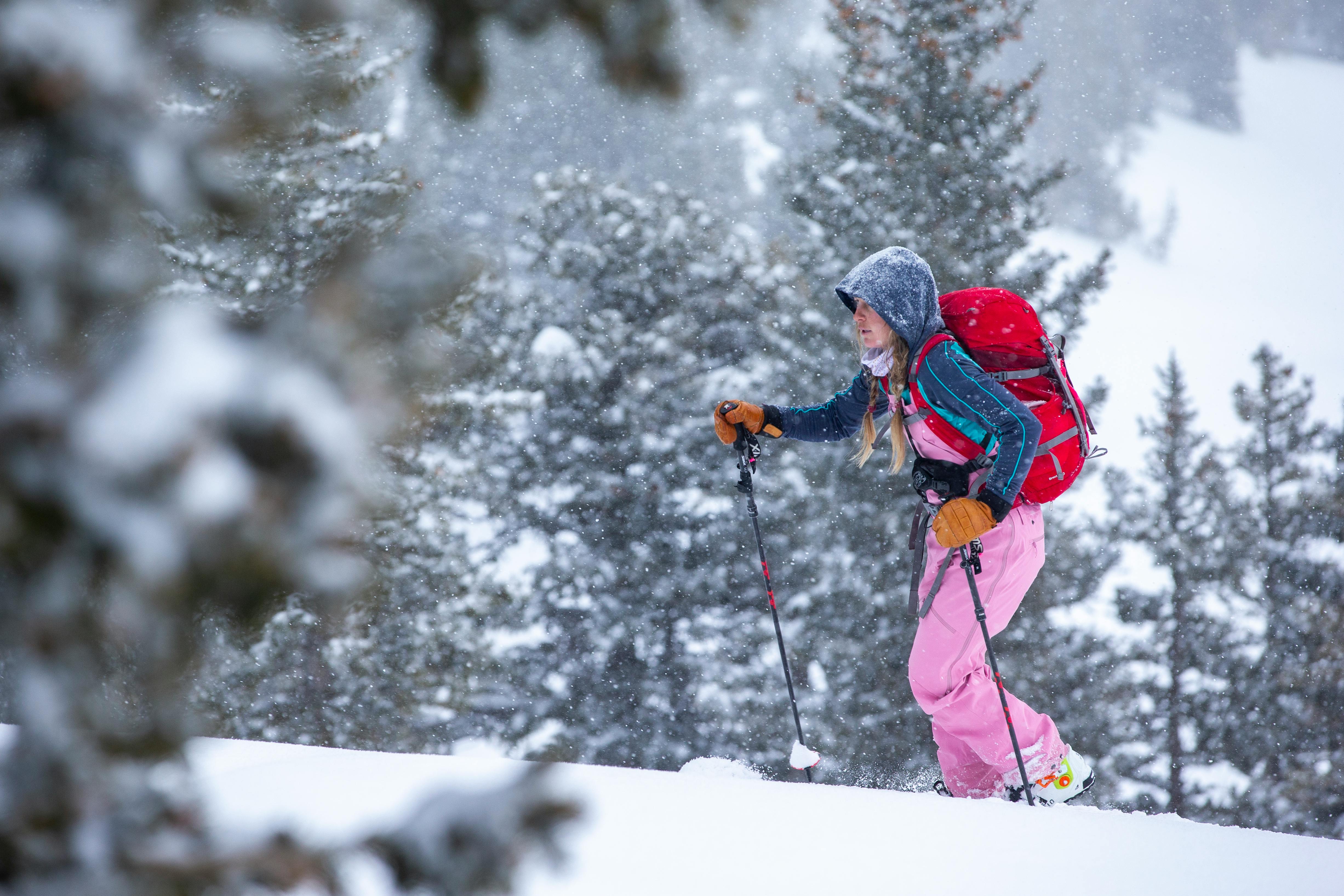 Woman hiking on skis in the backcountry in a blizzard.