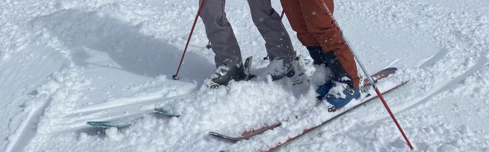 Two skiers with boots and ski boots.