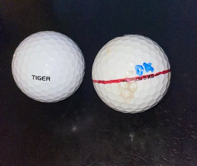Two Bridgestone Tour 2022 B XS Tiger Wood Edition Golf Balls. One worn and one new. 