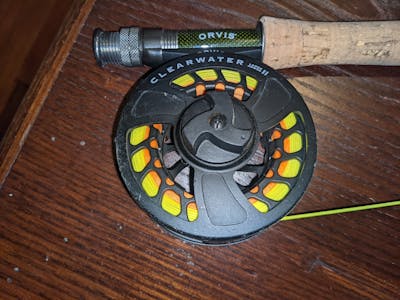 Up close photo of a rod and reel on a table.